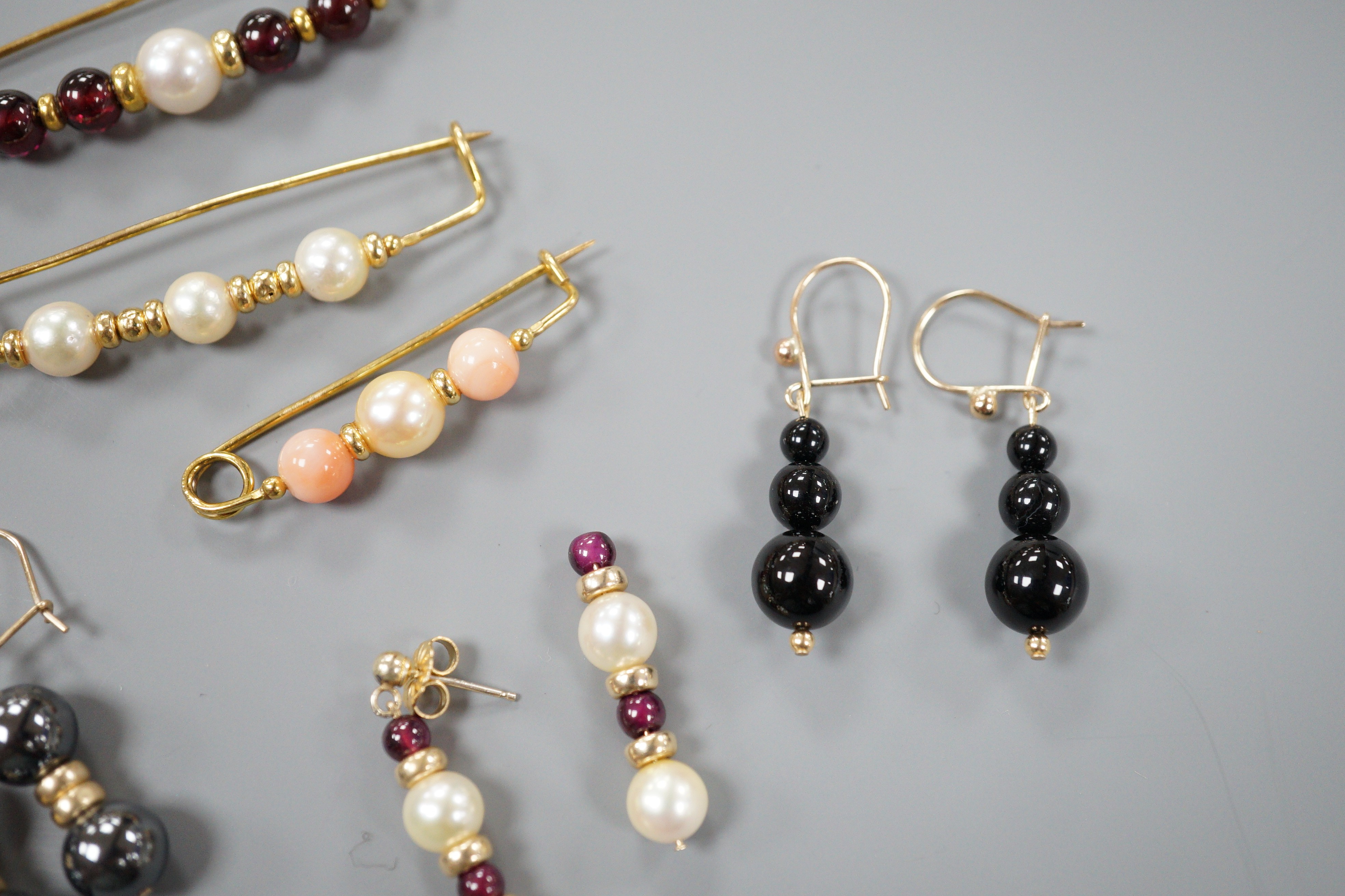 Three modern 9ct gold, cultured pearl and gem set brooches, largest 52mm and three modern pairs of yellow metal and gem set earrings, including hematite and 9k, gross weight 18.5 grams.